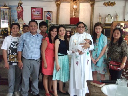 An Indonesian Extended Family gather together after the celebration of Baptism for a young child.